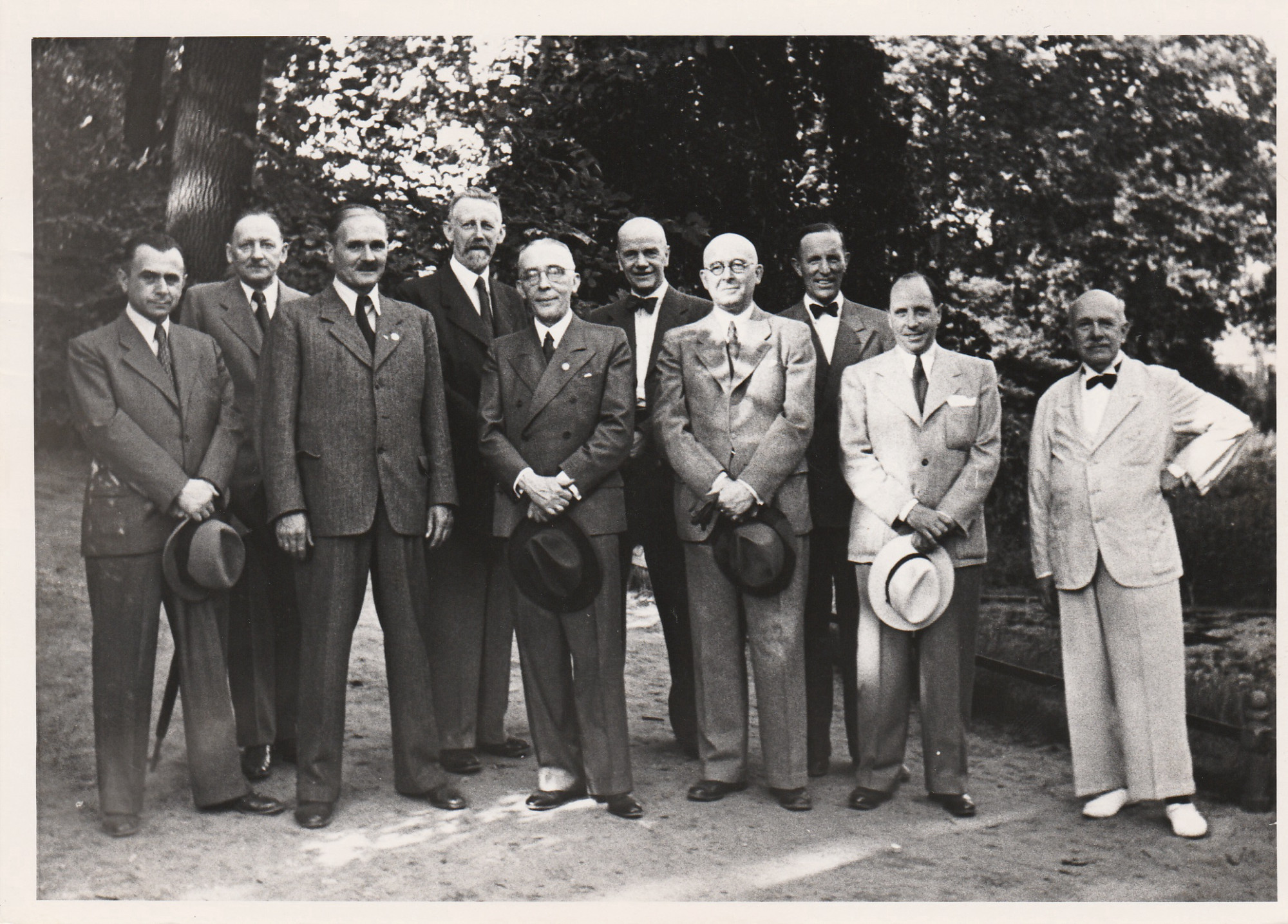 Black and white photograph: ten men in suits